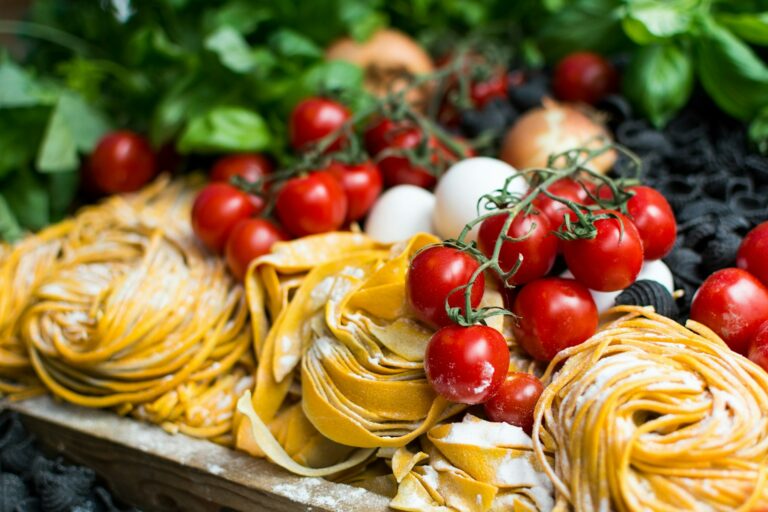 Nids de tagliatelles fraîches présentées avec des tomates cerises rouges en grappe  du restaurant la table de trois à Bordeaux.