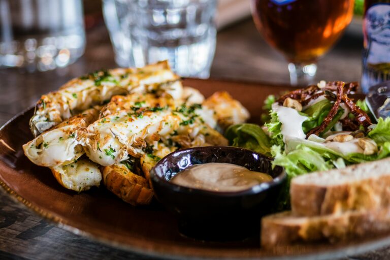 Queues de langoustines grillées à la planchanservies avec une sauce du pain et de la salade verte du restaurant la table de 3 à Bordeaux.